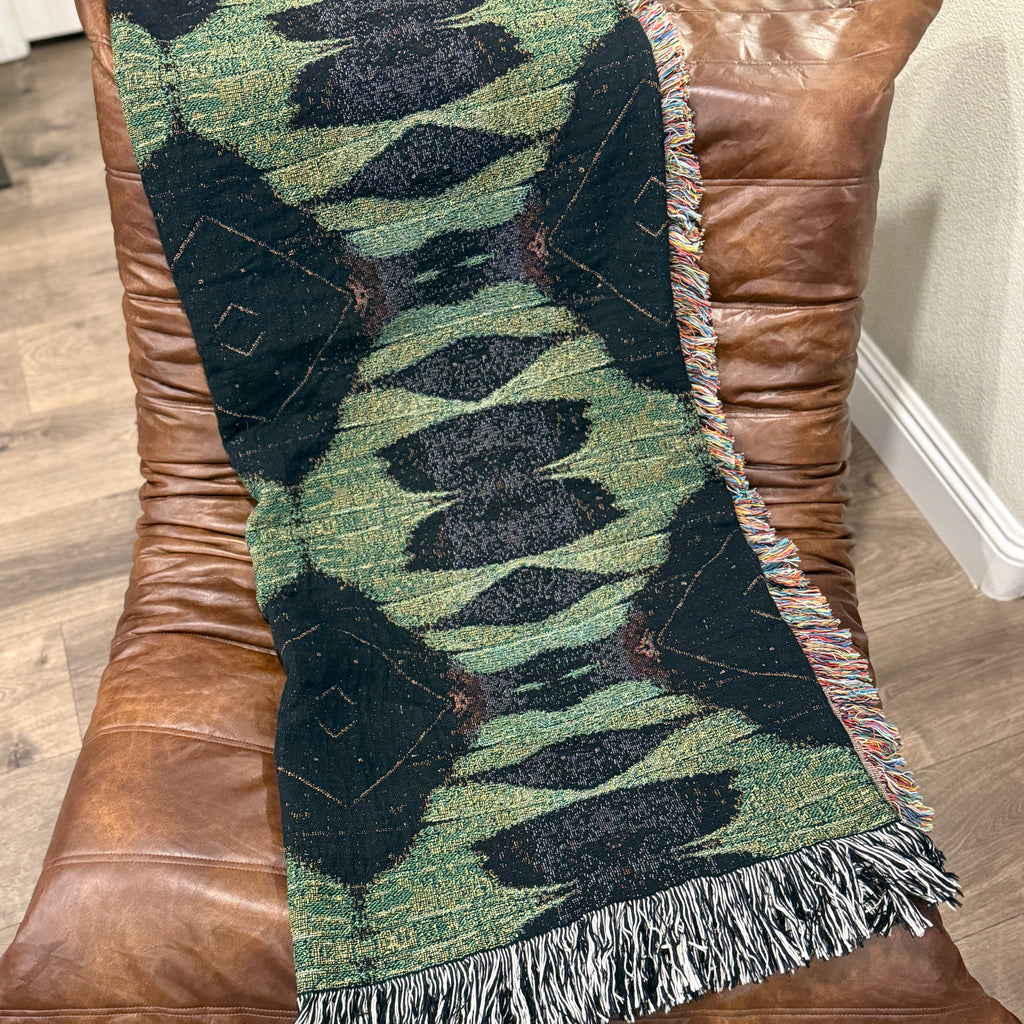 patterned throw blanket on a brown leather chair.