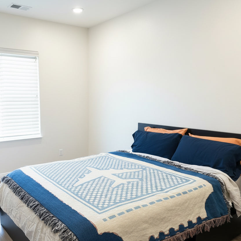 room with a blue and white checkered blanket, that is blue and creme featuring a large airplane design in the center of the blanket