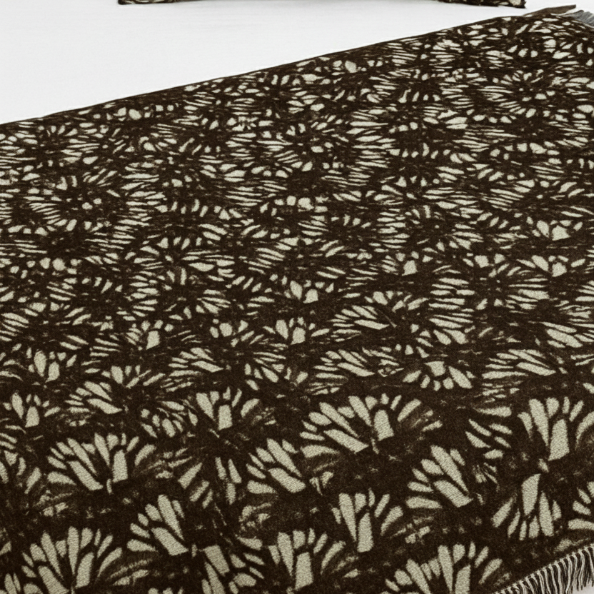 Brown Patterned blanket on a bed with white pillows