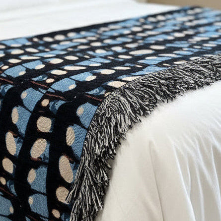 Patterned blanket draped over a bed in a bedroom setting