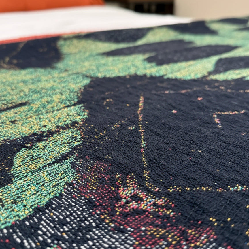 Close-up of a textured fabric with  patterns in green, black, and multicolor.